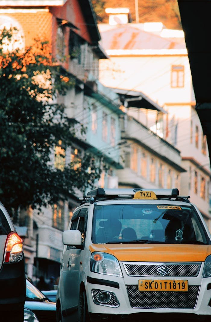 Suzuki taxi navigates through busy urban streets of Gangtok, India.