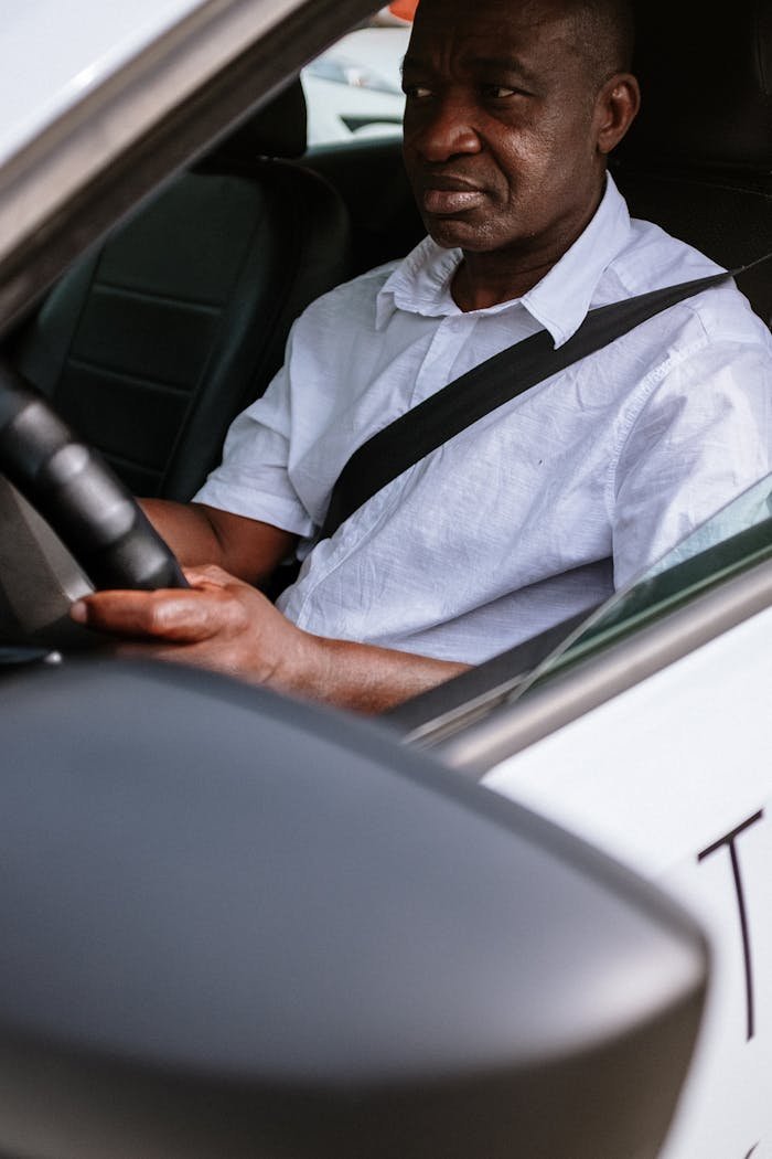 Man driving a car, focused on the road, representing transportation service.